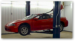 A salvaged car on a lift, ready to be dismantled.